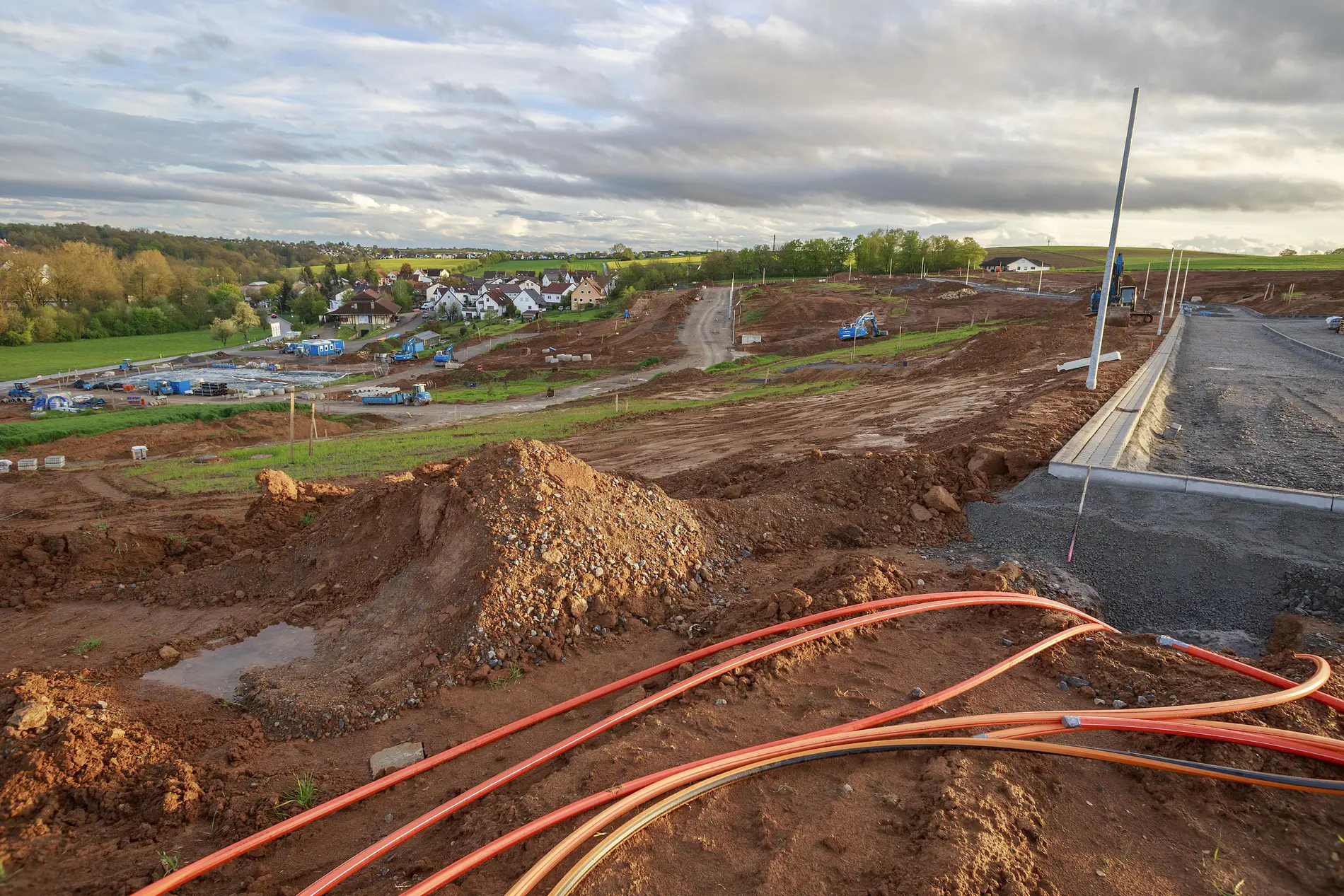 Ausbau von Telekommunikationsinfrastrukturen Baustelle in einem Neubaugebiet, im Vordergrund liegen Glasfaserkabel auf dem Boden