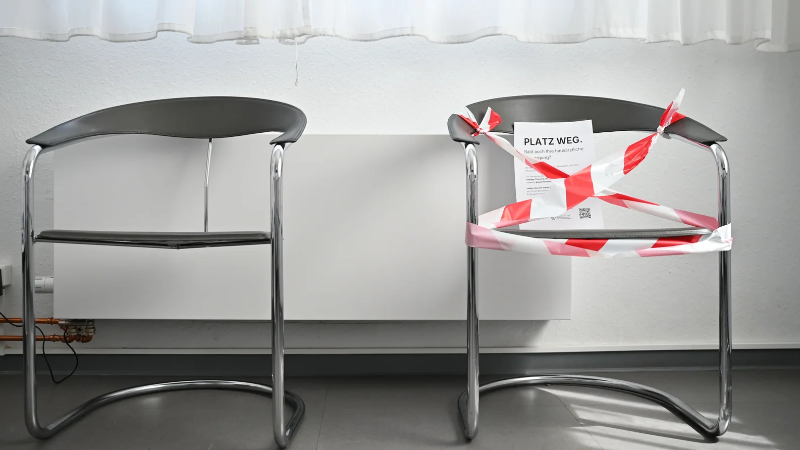 Blick auf einen abgesperrten Stuhl im Wartezimmer mit der Aufschrift "Platz weg"