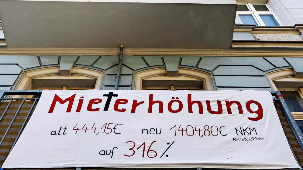 Das Bild zeigt einen Banner zur Mieterhöhungen an einem Haus hängen.