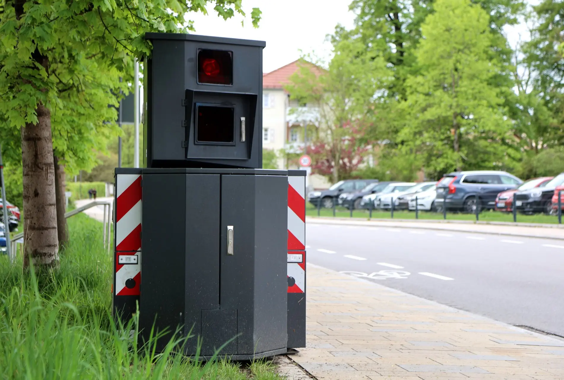 Mobiler Blitzer am Straßenrand neben einem Baum