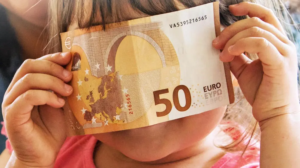 Kind hält einen 50-Euro-Schein