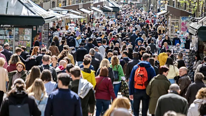 Touristenscharen laufen die Flaniermeile Ramblas in Barcelona entlang.