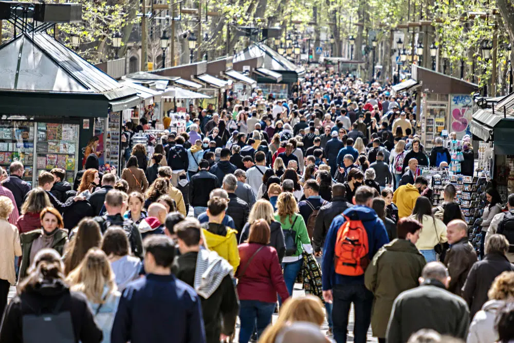 Touristenscharen laufen die Flaniermeile Ramblas in Barcelona entlang.