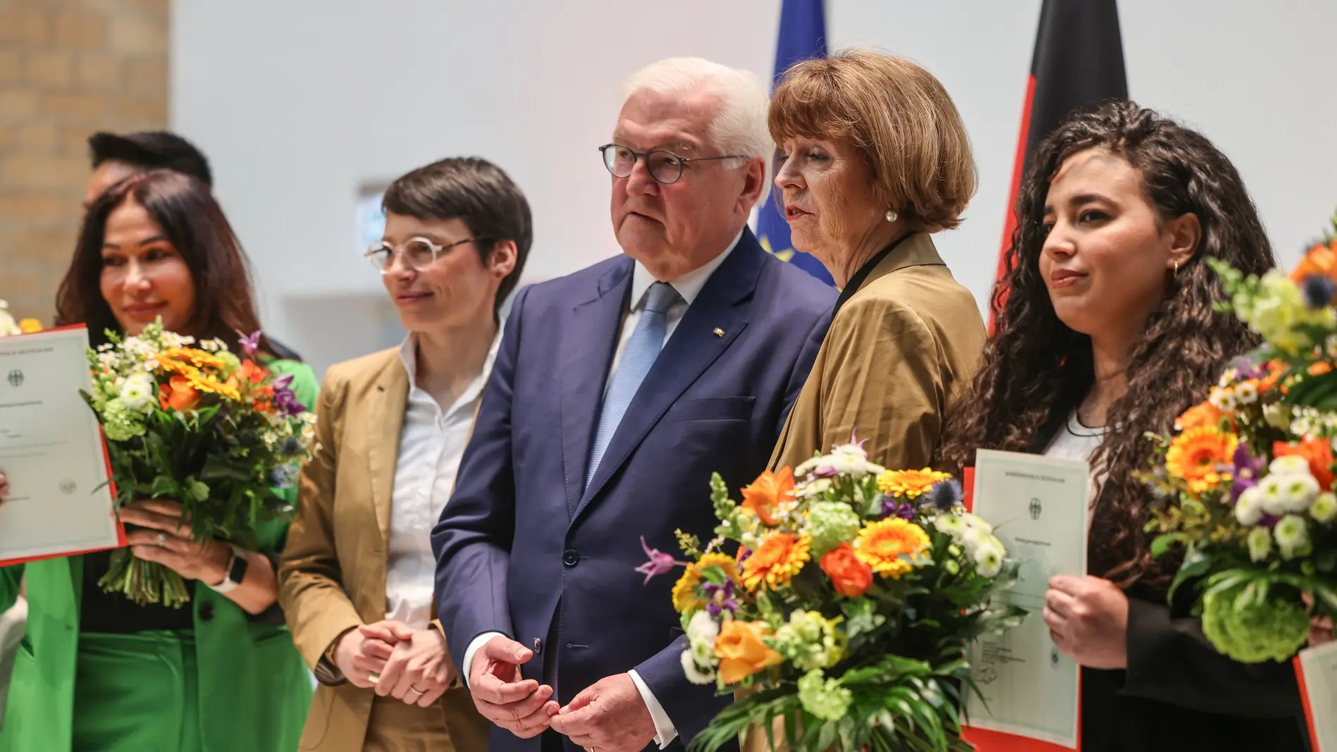 Bundespräsident Steinmeier (M), Kölns Oberbürgermeisterin Reker (2.v.r.) und Nordrhein-Westfalens Integrationsministerin Paul (2.v.l.), stehen auf einer Einbürgerungsfeier im April zwischen neu Eingebürgerten. Frank-Walter Steinmeier mit frisch eingebürgerten Menschen