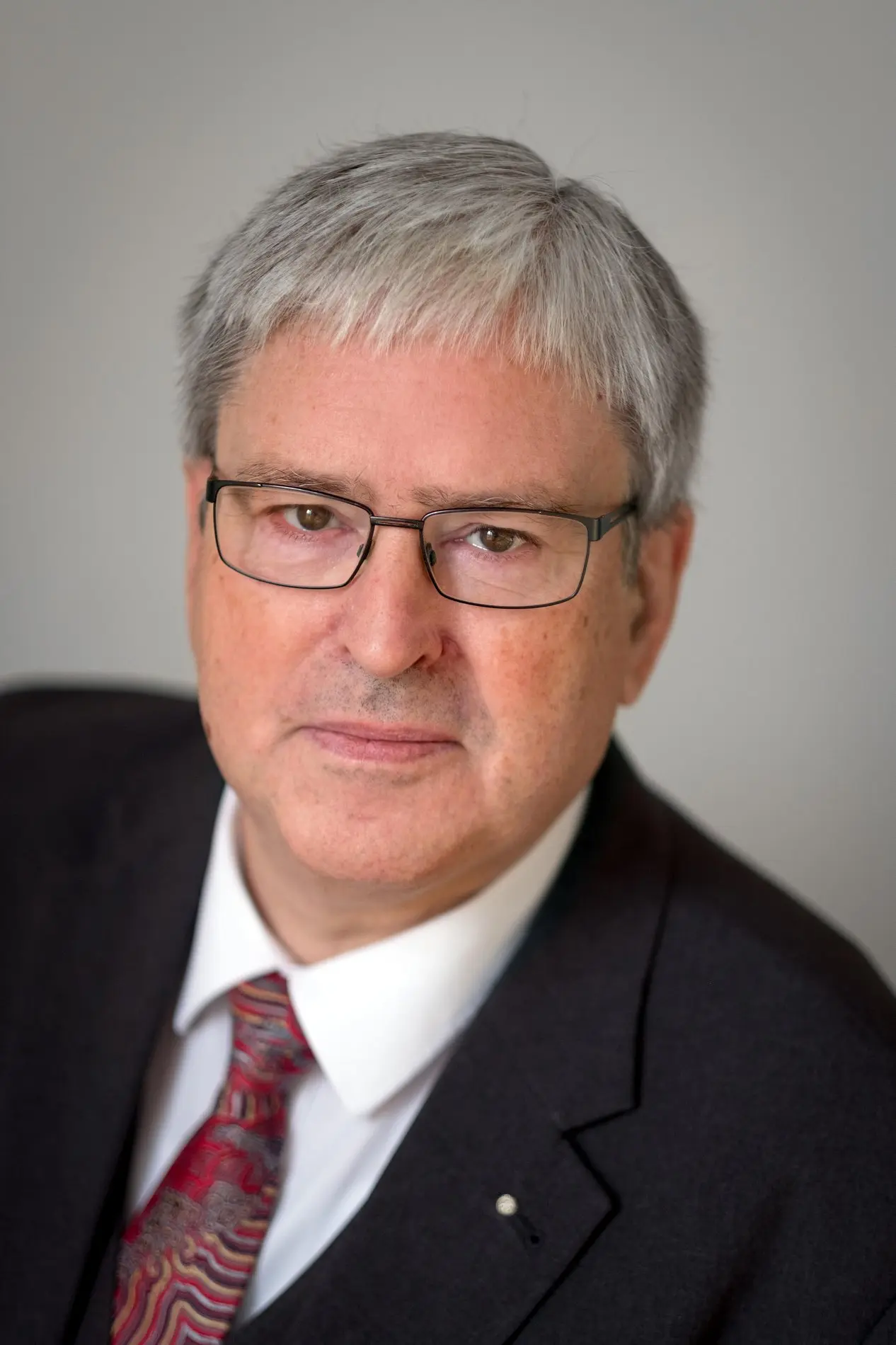 Porträt von Jörg Steinbach im Anzug mit Krawatte und einer Brille