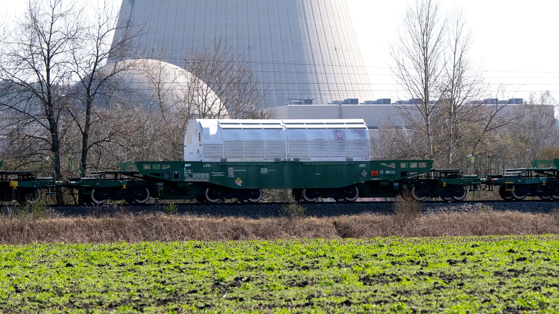 Ein Castor-Transport fährt an einem Atomkraftwerk vorbei