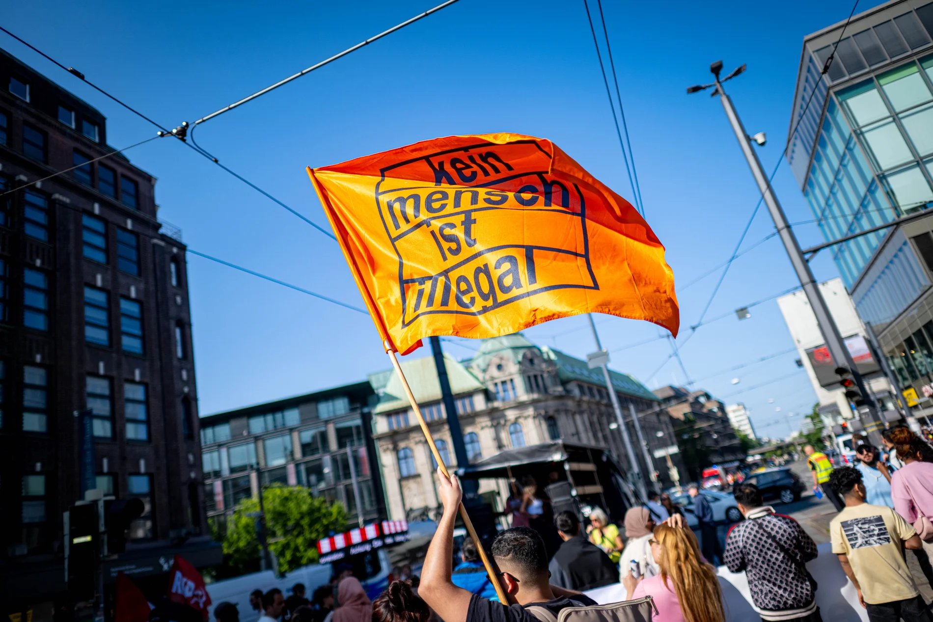 Auf einer Fahne steht geschrieben "kein mensch ist illegal"