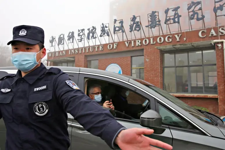 Das Foto zeigt einen Polizisten mit Mundschutz vor einem Forschungsinstitut in China. 