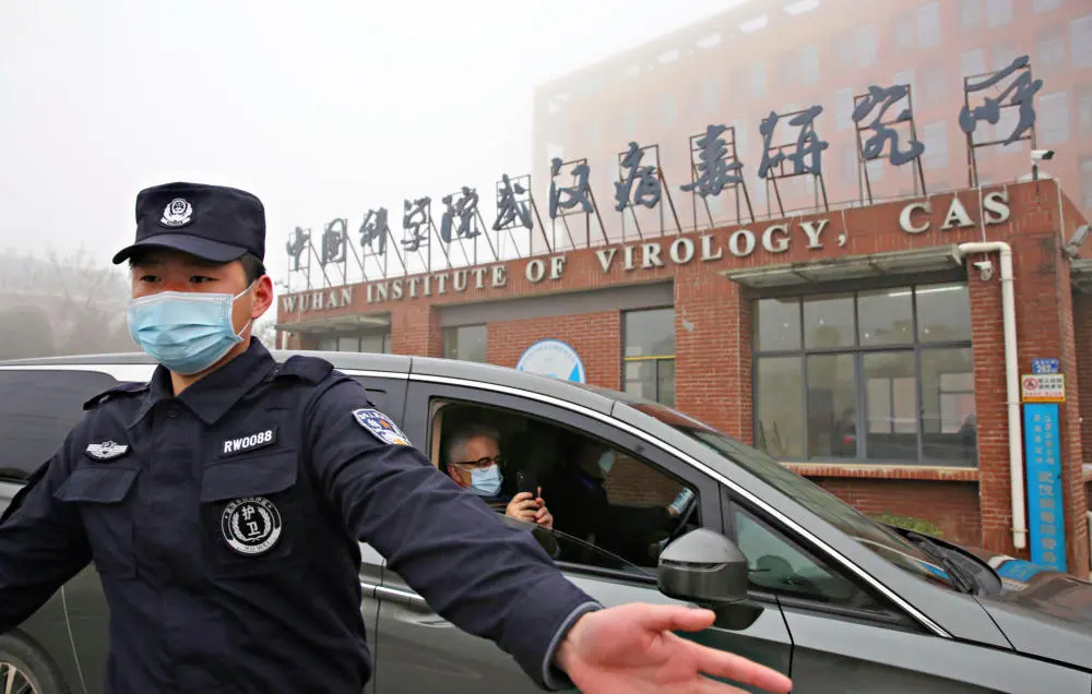 Das Foto zeigt einen Polizisten mit Mundschutz vor einem Forschungsinstitut in China. 