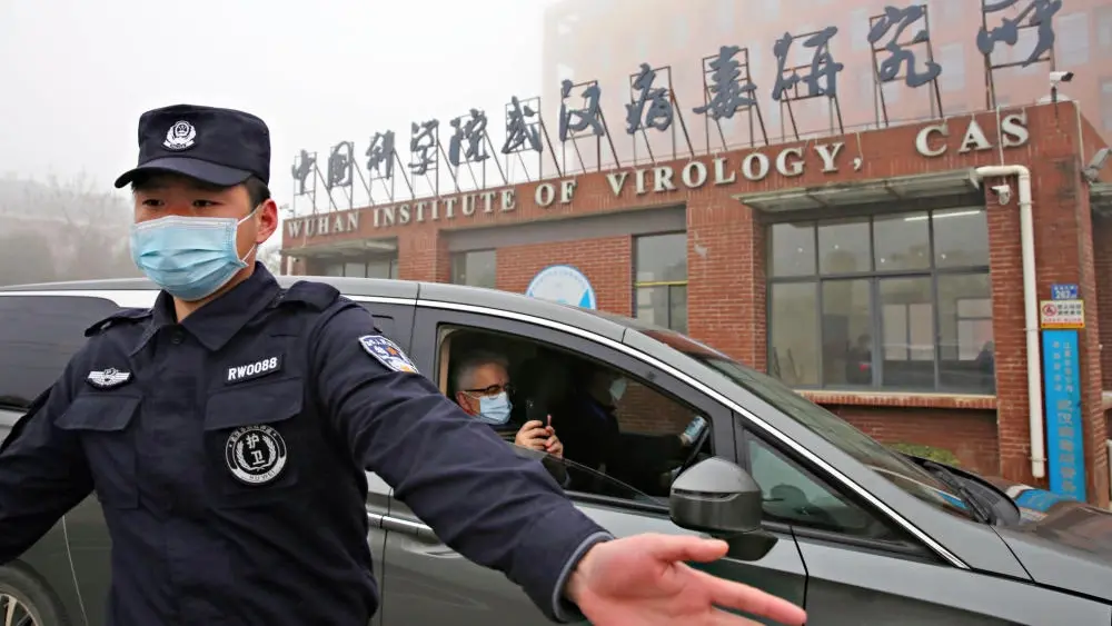 Das Foto zeigt einen Polizisten mit Mundschutz vor einem Forschungsinstitut in China. 