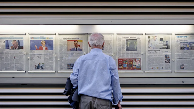 Mann studiert Zeitungsaushänge