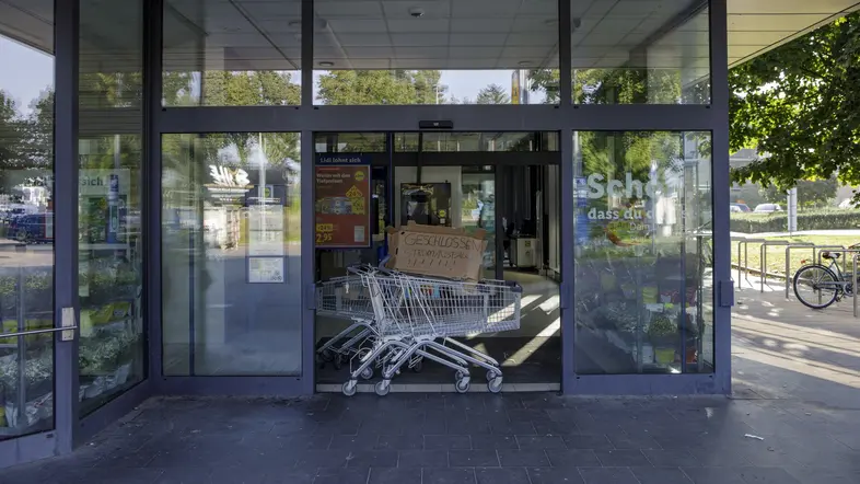 Im Eingang eines Supermarkts steht ein Einkaufswagen "Geschlossen Stromausfall"