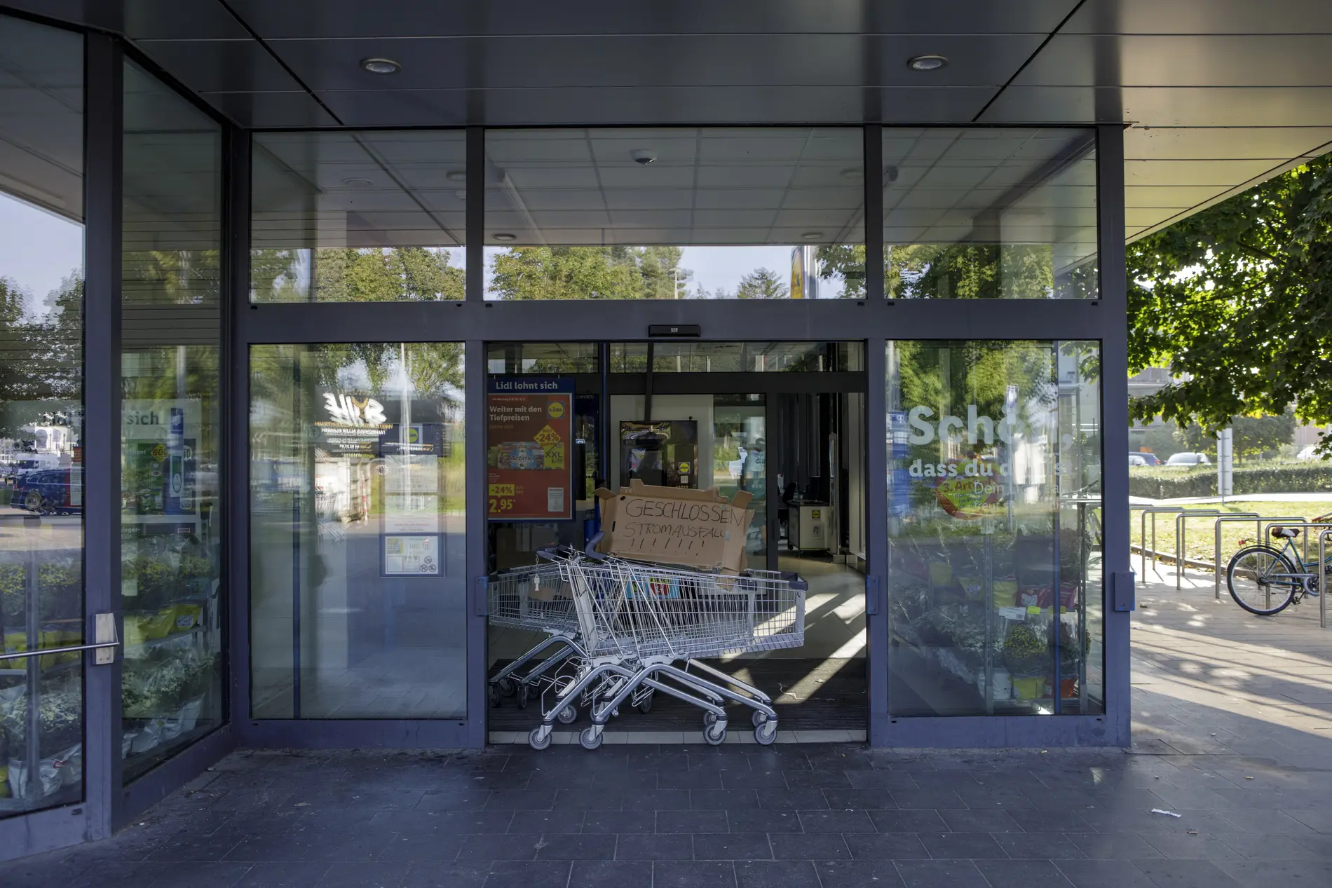 Im Eingang eines Supermarkts steht ein Einkaufswagen "Geschlossen Stromausfall"
