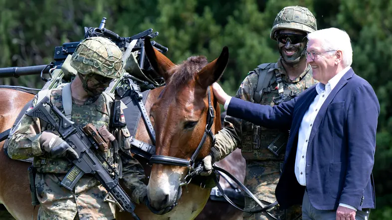 Bundespräsident Frank-Walter Steinmeier steht bei einem Besuch der Gebirgsjägerbrigade 23 neben Soldaten und einem Muli auf dem Übungsplatz Reiteralpe.