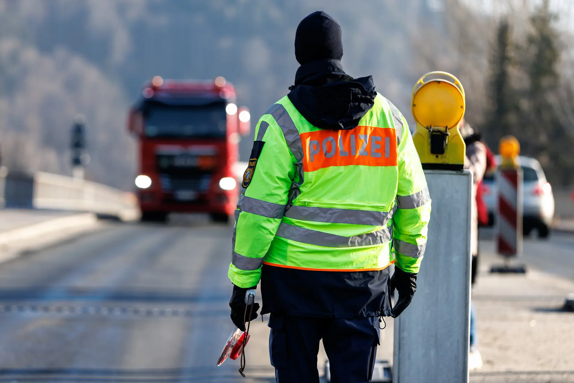Grenzpolizei Polizist mit Warnschild von hinten