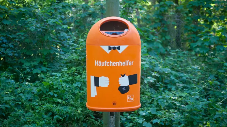 Ein Abfalleimer an einem Waldweg in Berlin Wannsee