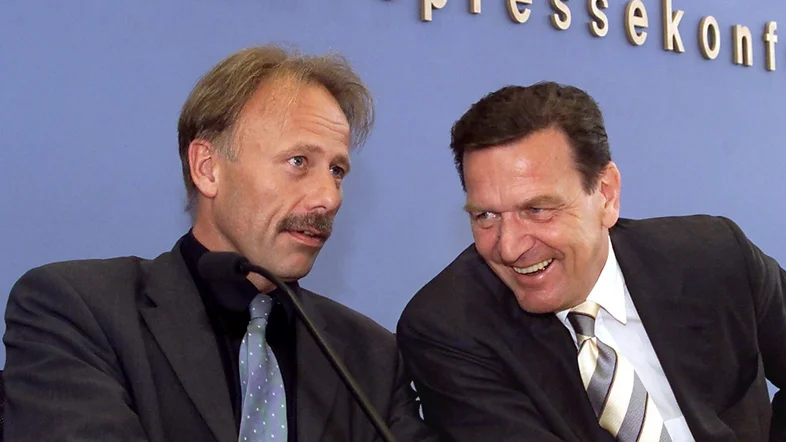 Lachend unterhalten sich Gerhard Schröder und Jürgen Trittin