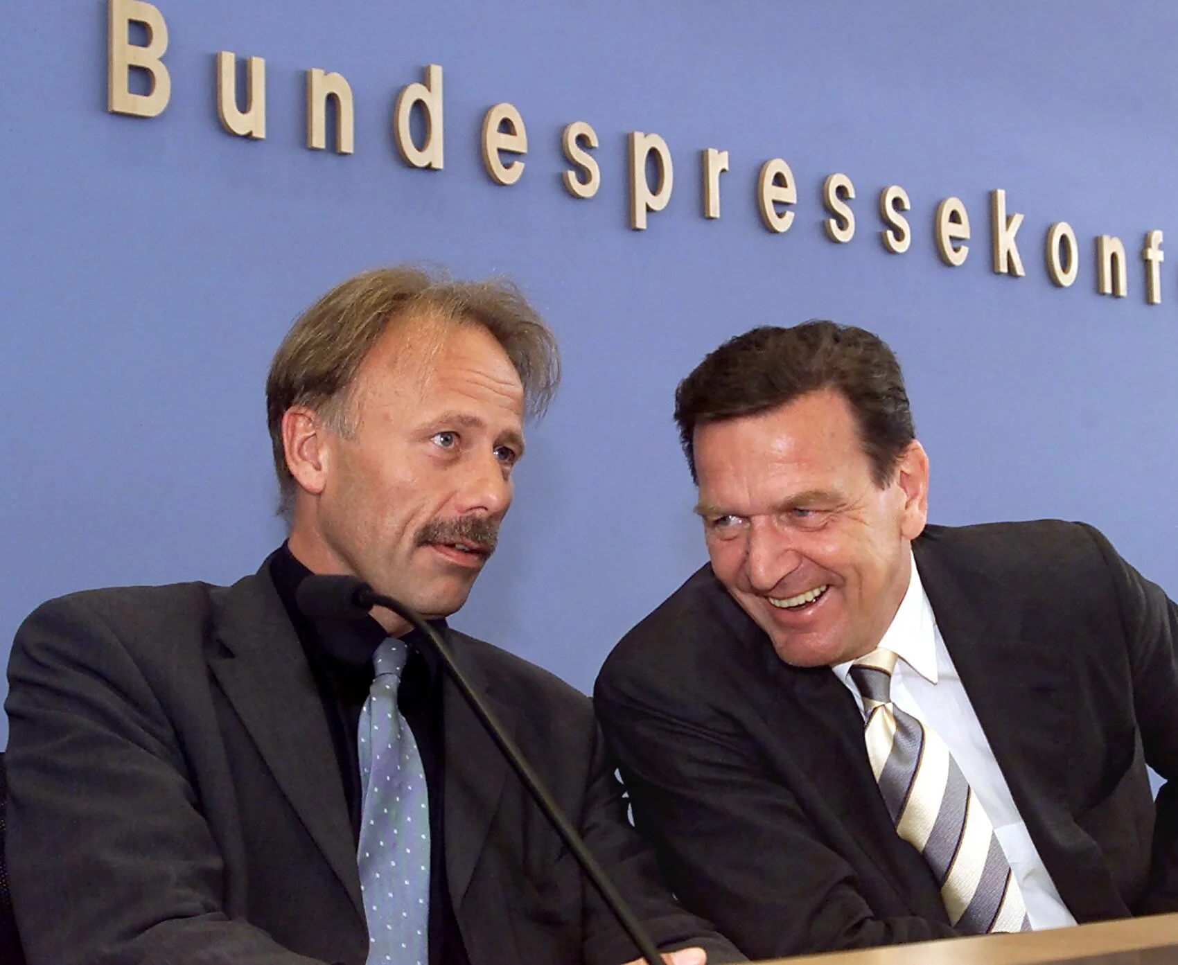 Lachend unterhalten sich Gerhard Schröder und Jürgen Trittin