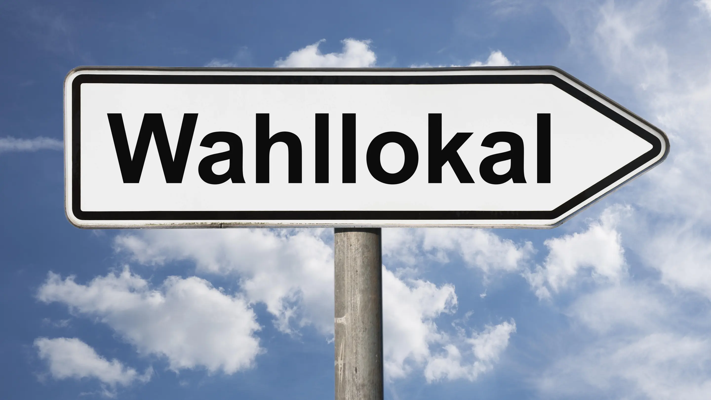 Wie in Deutschland gewählt wird Detailansicht eines Wegweisers mit der Aufschrift Wahllokal