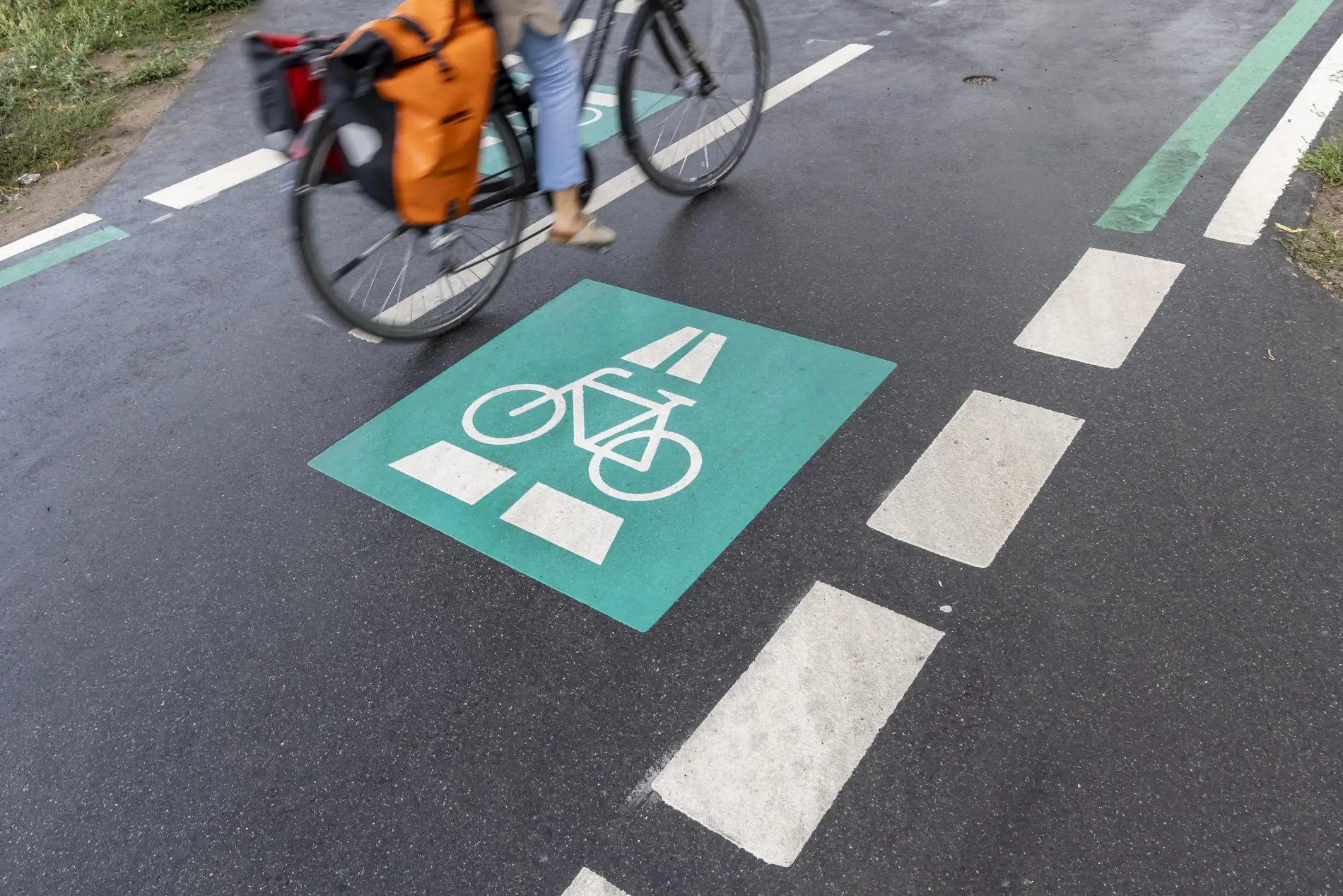 Eine Frau fährt mit dem Fahrrad über einen Fahrradweg. 