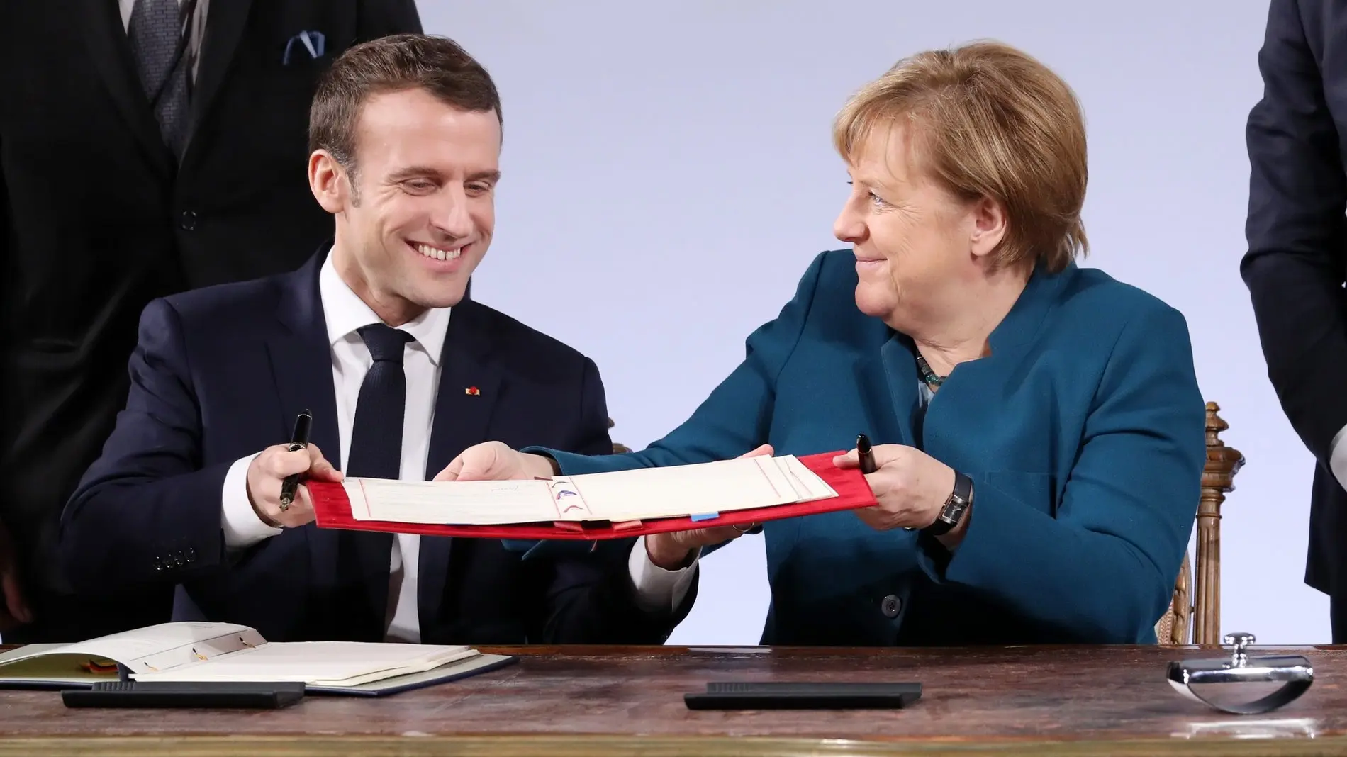 Angela Merkel und Emmanuel Macron in Aachen Angela Merkel und Emmanuel Macron halten den Vertrag von Aachen in der Hand