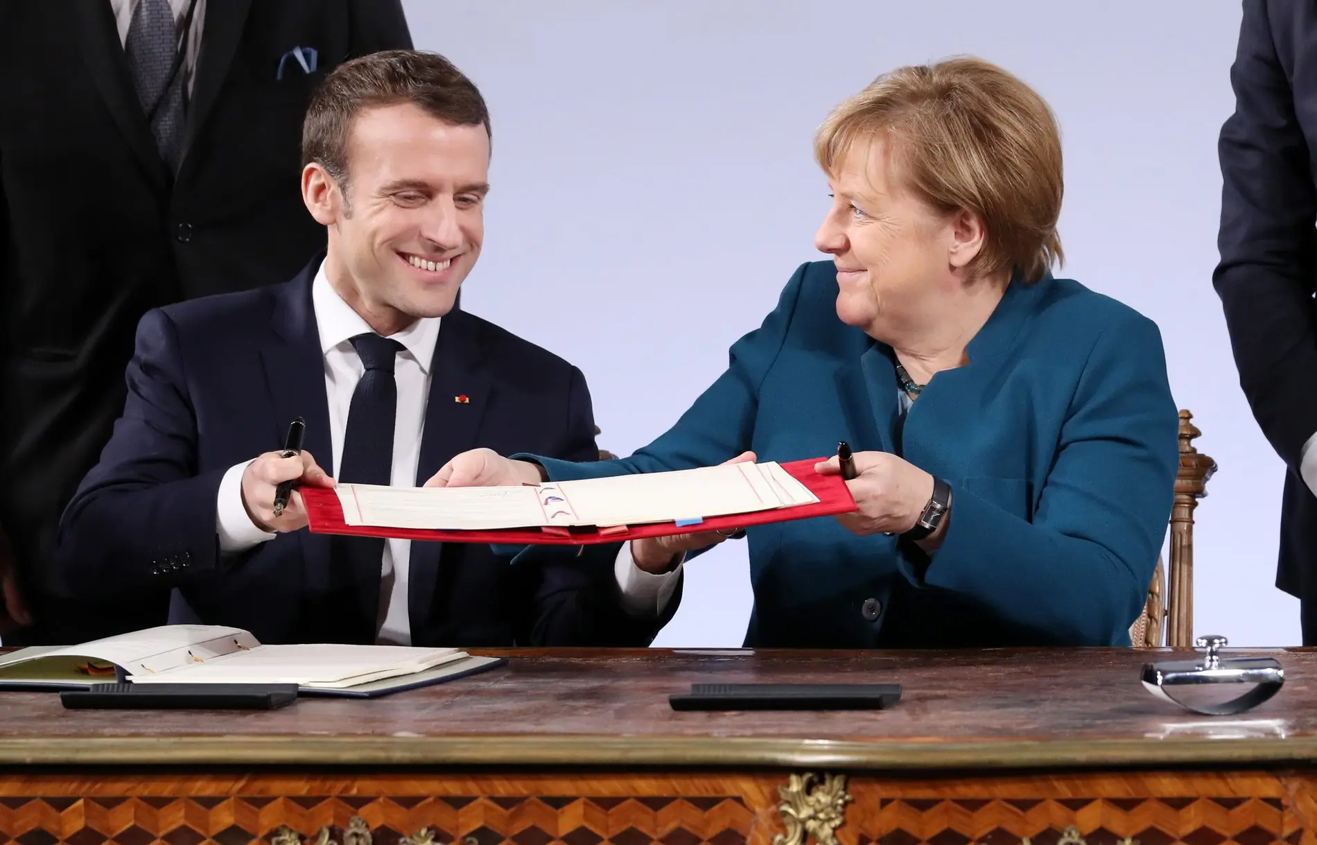 Angela Merkel und Emmanuel Macron in Aachen Angela Merkel und Emmanuel Macron halten den Vertrag von Aachen in der Hand