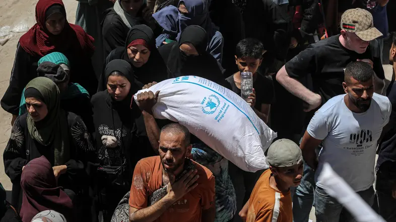 Palästinenser tragen Säcke des Welternährungsprogramms in Gaza