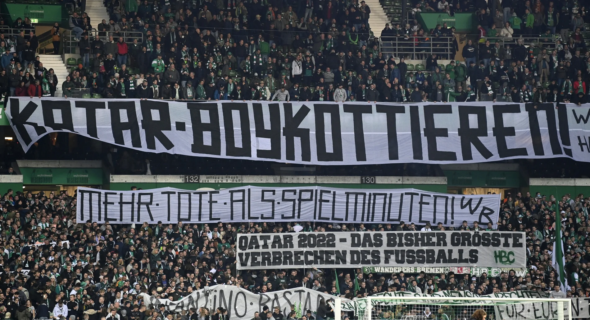 Blick auf ein Banner "Katar boykottieren, mehr Tote als Spielminuten" im Stadion