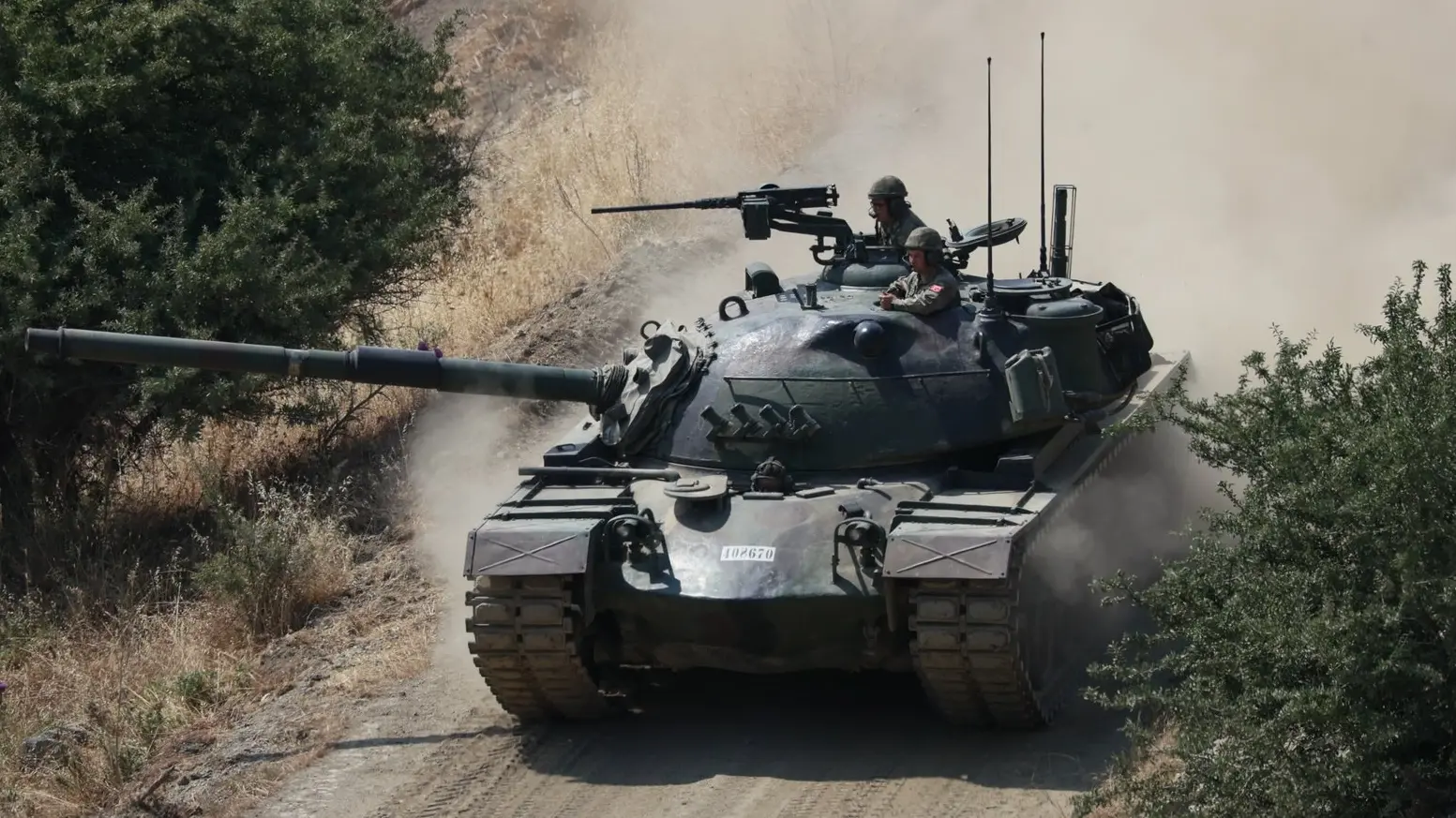 Ein Panzer auf sandiger Straße von oben fotografiert.