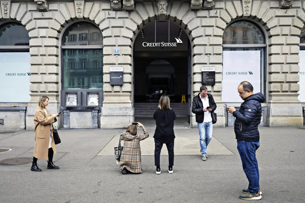 Touristen vor einer Filiale der Credit Suisse