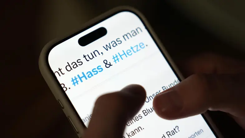 Smartphonedisplay mit den Worten Hetze und Hass