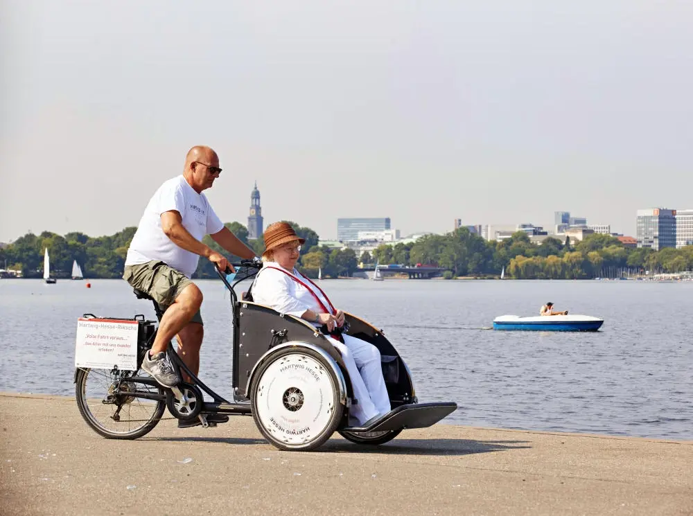 Ausflug mit dem Lastenrad Pflegefachkraft unternimmt mit einer Seniorin einen Ausflug mit dem Lastenrad