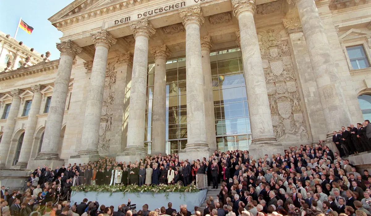 Abgeordnete und Ehrengäste stehen 1999 bei der Feier vor dem Reichstagsgebäude