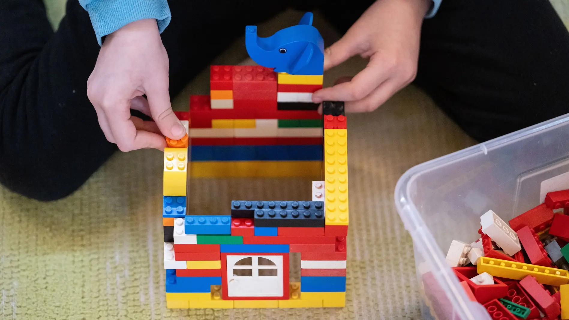 Ein Kind spielt in einem Kindergarten mit Bausteinen.