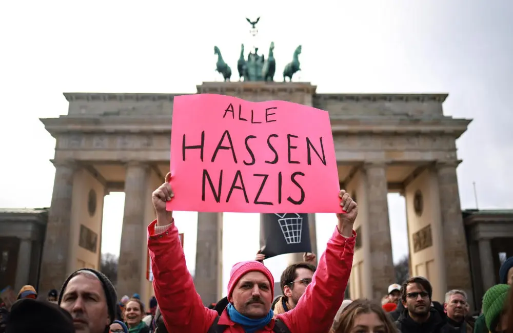 Ein Demoteilnehmer mit dem Schild "Alle hassen Nazis"