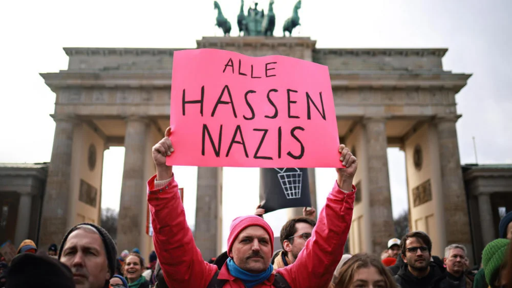 Ein Demoteilnehmer mit dem Schild "Alle hassen Nazis"