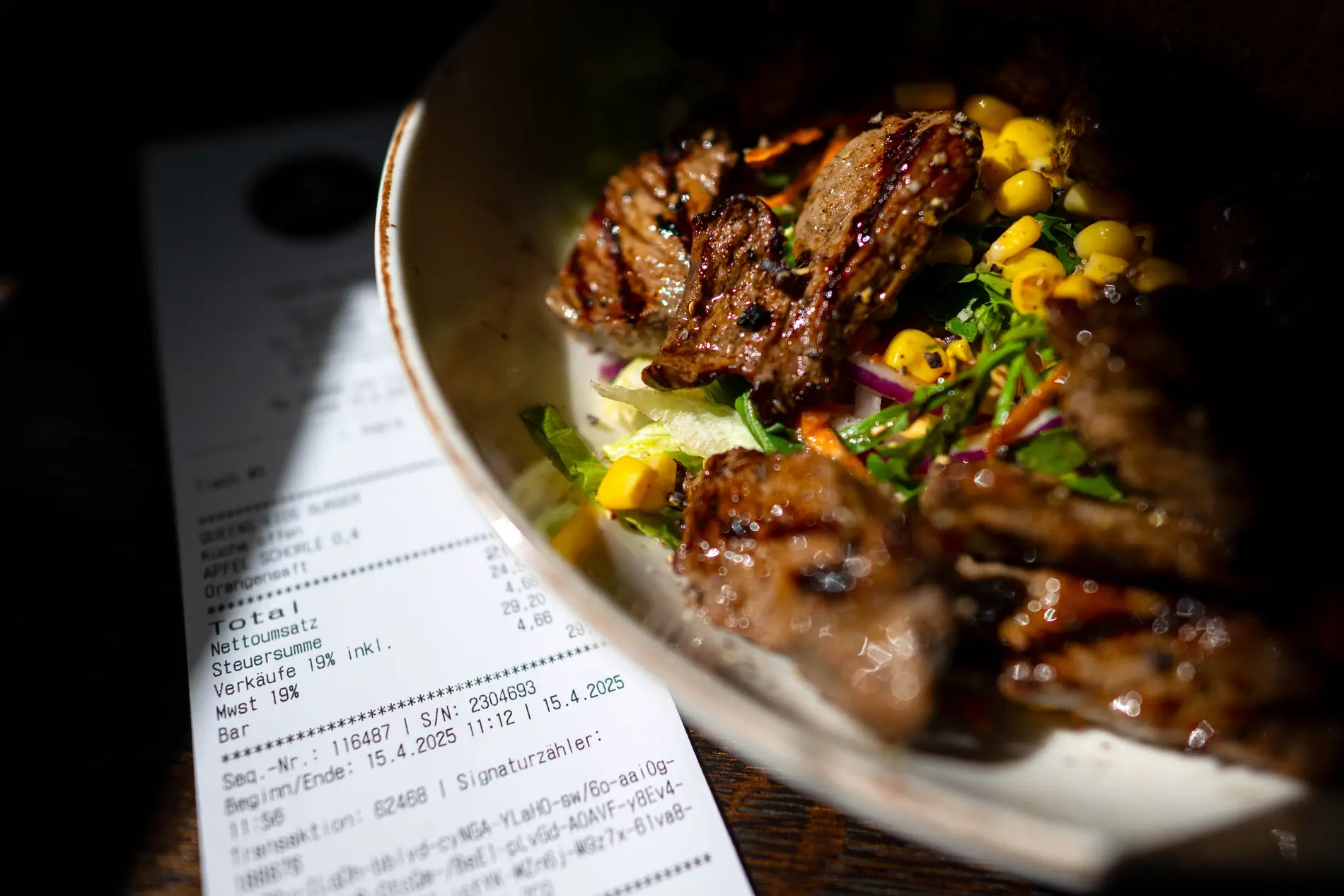 Eine Rechnung der Mehrwertsteuer neben eine vollen Teller in einem Restaurants.