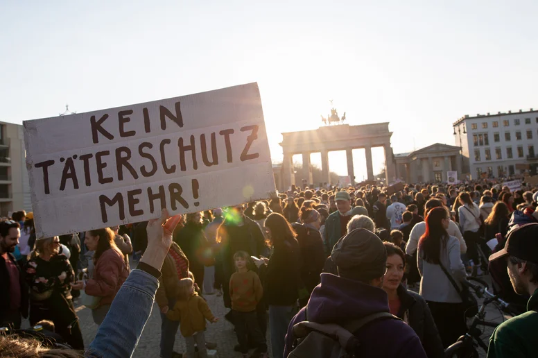 Demonstranten mit Schild "Kein Täterschutz mehr!"