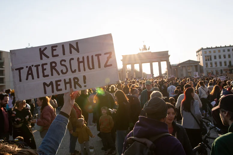 Demonstranten mit Schild "Kein Täterschutz mehr!"