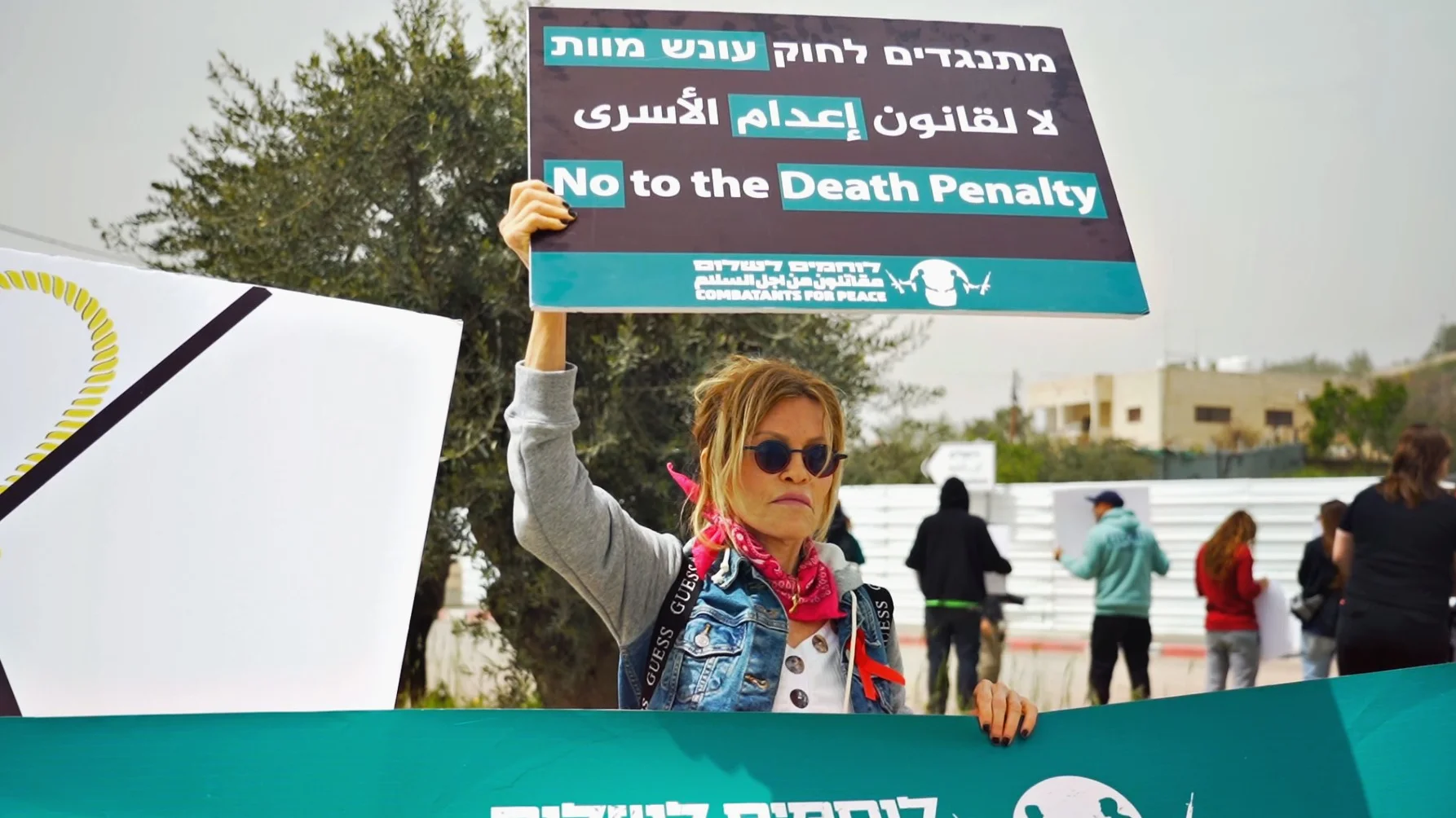 Frau hält ein Schild mit "No to the Death Penalty" hoch