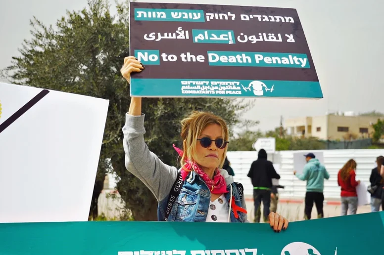 Frau hält ein Schild mit "No to the Death Penalty" hoch