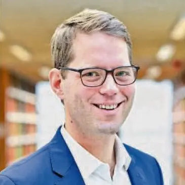 Sven T. Siefken lächeln im Porträt mit Brille.