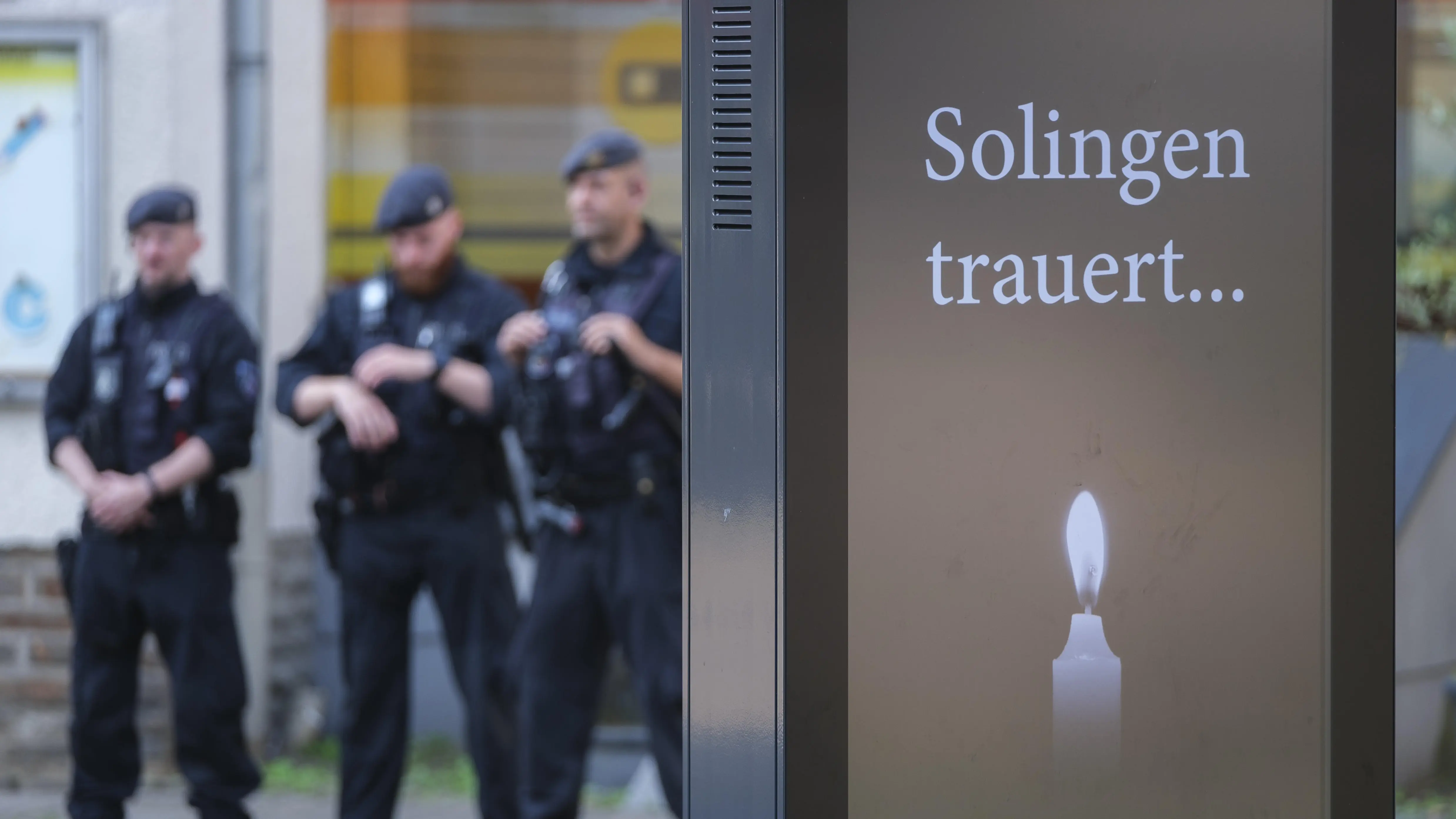 Sicherheitspaket der Ampelkoalition Polizisten stehen hinter einer Anzeigentafel "Solingen trauert …".