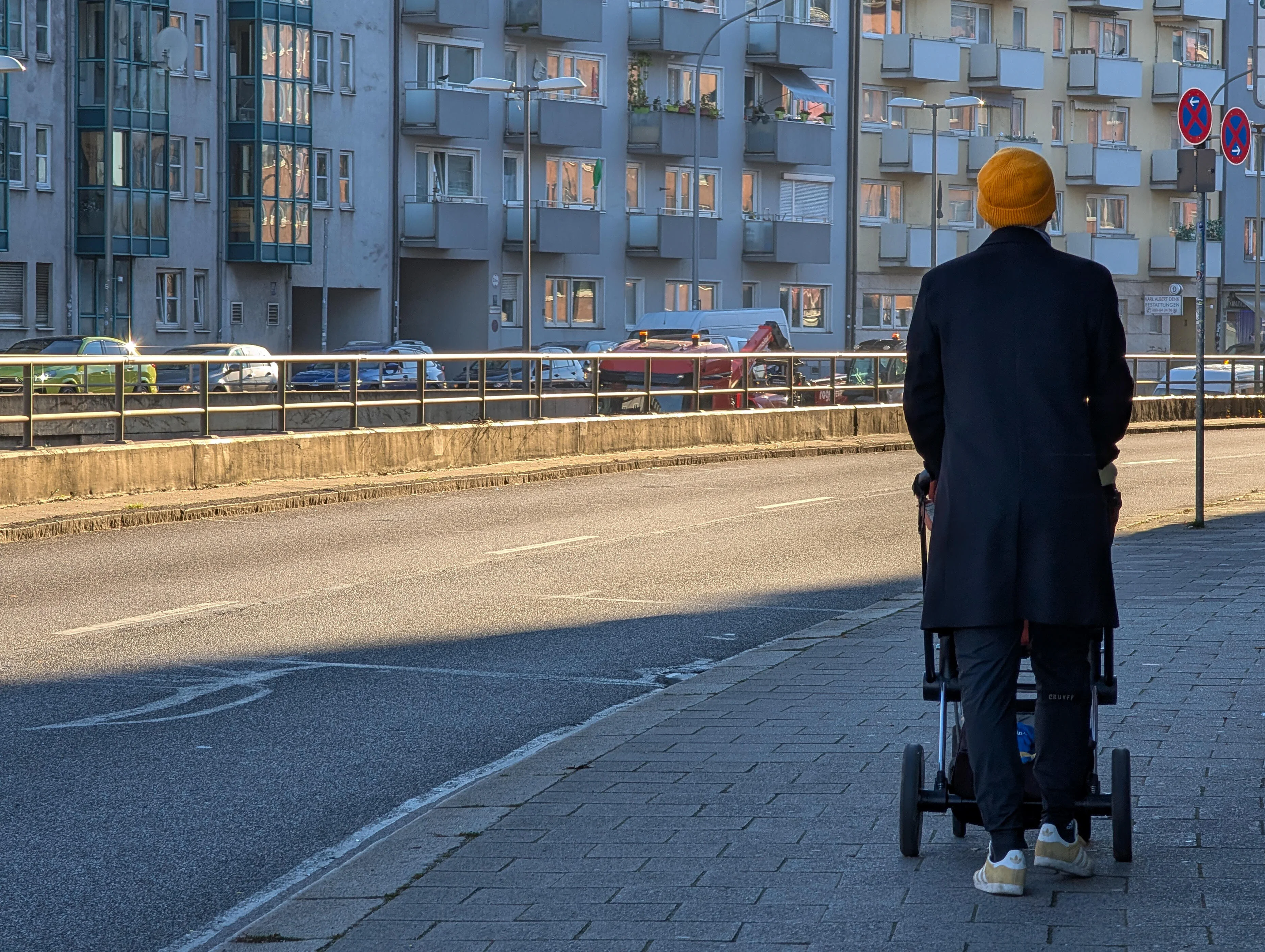 Mann schiebt Kinderwagen auf dem Bürgersteig