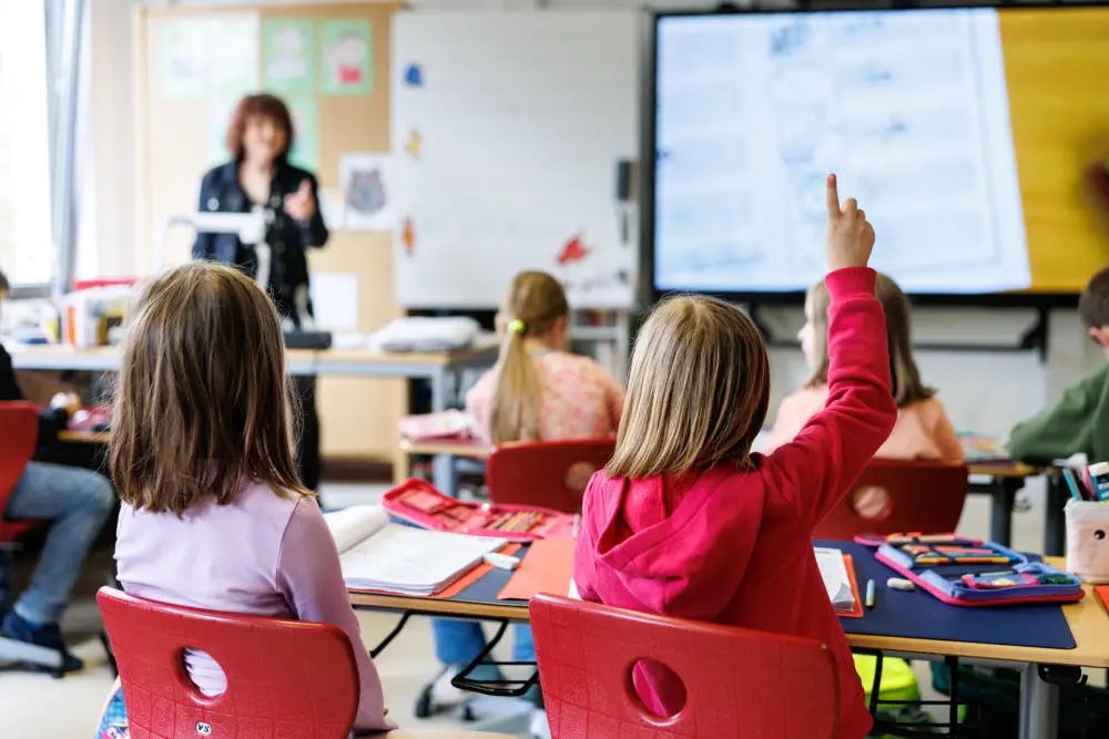 Zusammenlegung der Bildungs- und Familienpolitik Schüler sitzen während des Unterrichts auf ihren Plätzen und melden sich.
