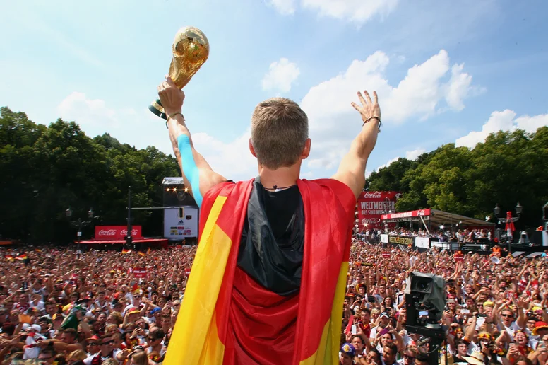 Bastian Schweinsteiger jubelt mit dem WM-Pokal auf der Fanmeile in Berlin