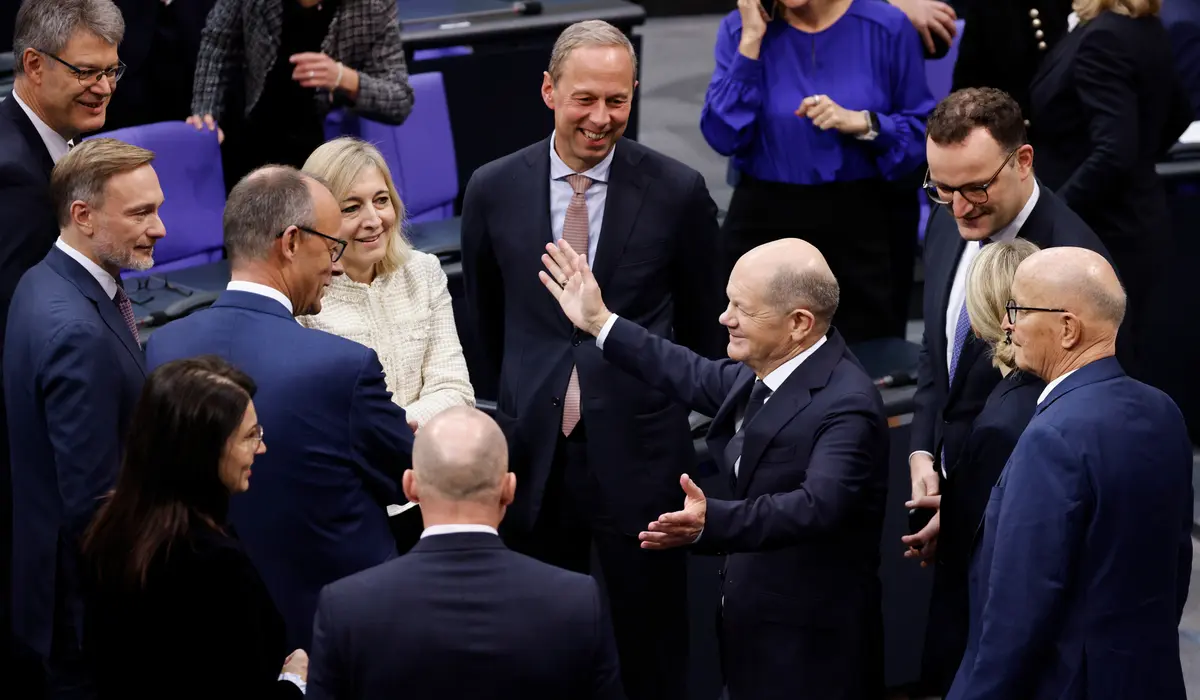 Olaf Scholz, Christian Lindner, Friedrich Merz und weitere lachen im Plenum