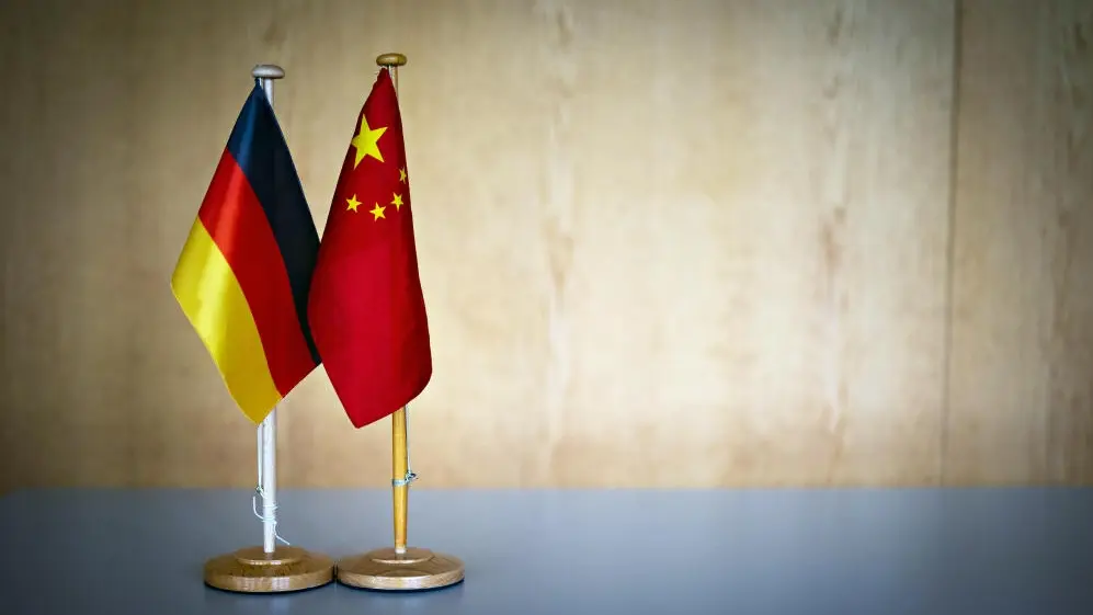Handelspartner China Das Bild zeigt eine deutsche Flagge neben einer chinesischen Flagge auf einem Tisch.