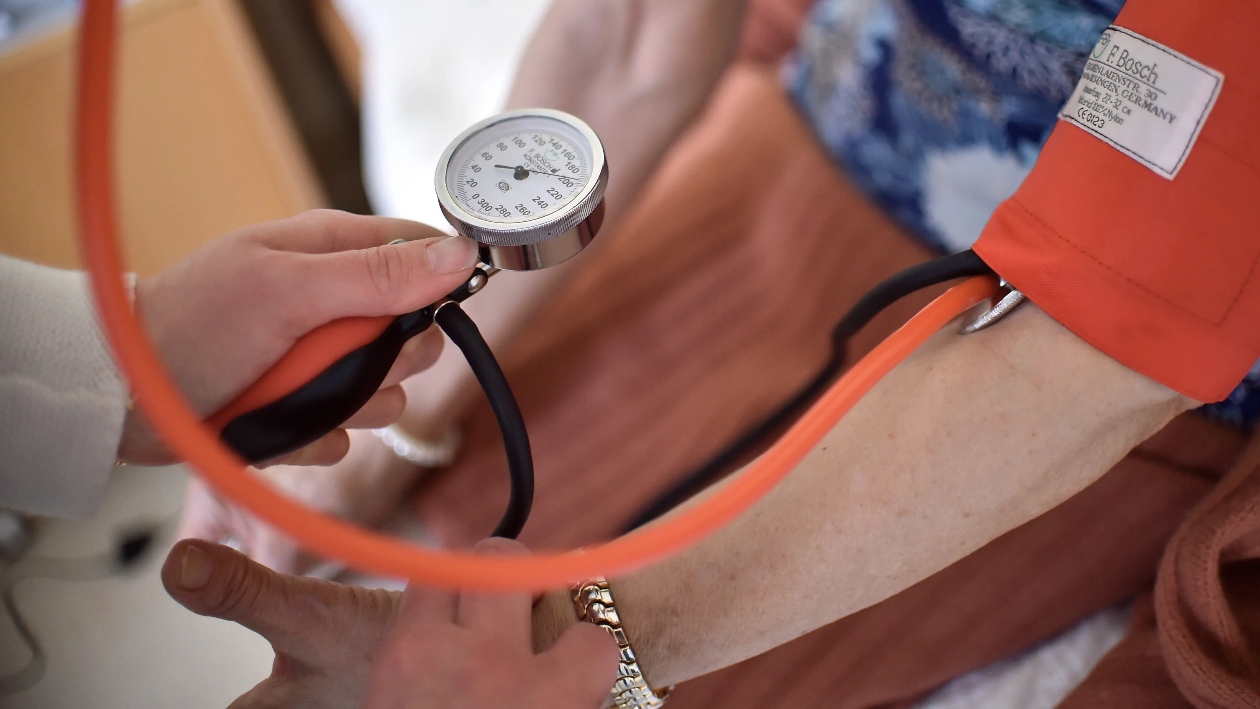 Eine Pflegekraft misst bei Bewohnerin einer Pflegeeinrichtung den Blutdruck.