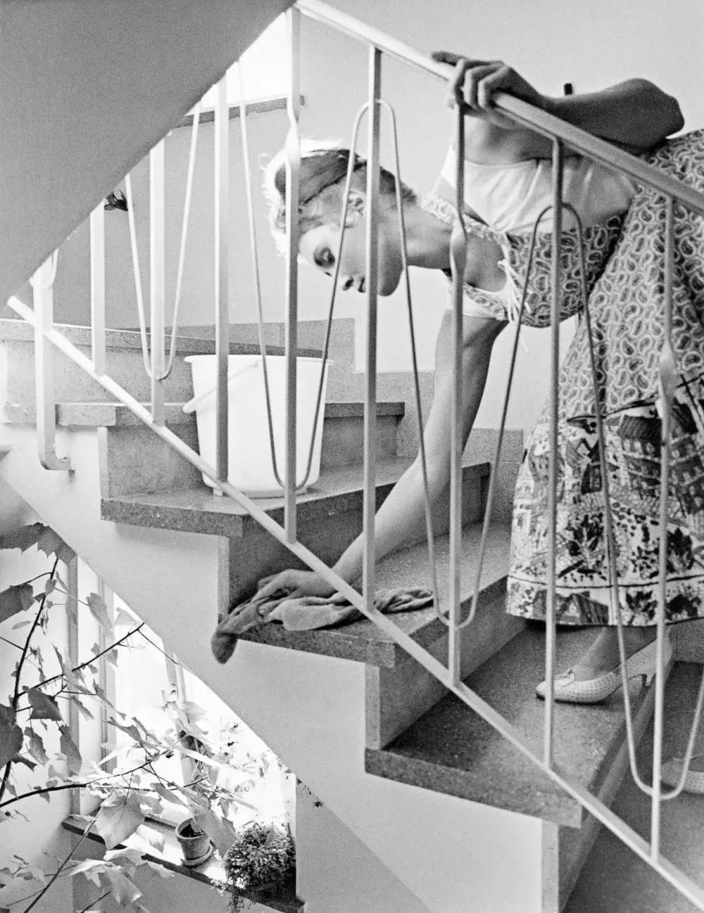 Eine Frau putzt ein Treppenhaus.